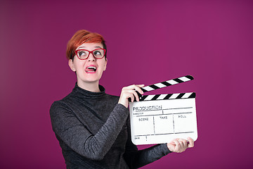 Image showing woman holding movie clapper isolated on pink background