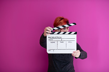 Image showing woman holding movie clapper isolated on pink background