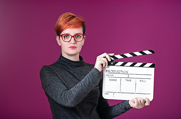 Image showing woman holding movie clapper isolated on pink background