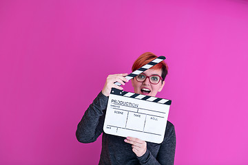 Image showing woman holding movie clapper isolated on pink background