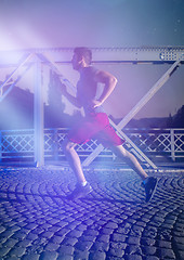 Image showing man jogging across the bridge in the city