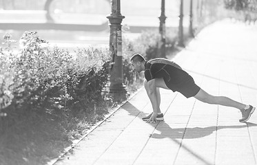 Image showing athlete man warming up and stretching