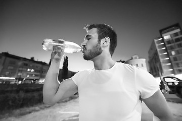 Image showing man drinking water after running session