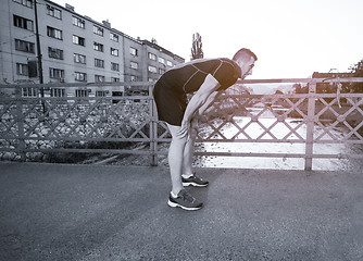 Image showing man jogging across the bridge at sunny morning