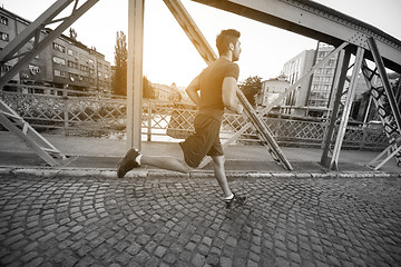 Image showing man jogging across the bridge at sunny morning