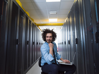 Image showing engineer working on a laptop in server room