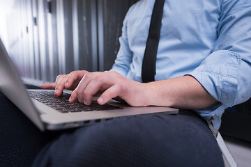 Image showing engineer working on a laptop in server room