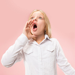 Image showing Isolated on pink young casual teen girl shouting at studio