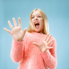 Image showing Portrait of the scared girl on blue