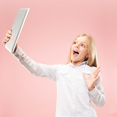 Image showing Teen girl with laptop. Love to computer concept. Attractive female half-length front portrait, trendy pink studio backgroud.