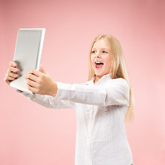 Image showing Teen girl with laptop. Love to computer concept. Attractive female half-length front portrait, trendy pink studio backgroud.