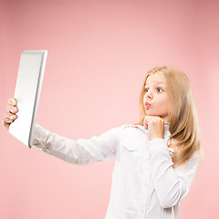 Image showing Teen girl with laptop. Love to computer concept. Attractive female half-length front portrait, trendy pink studio backgroud.