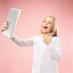 Image showing Teen girl with laptop. Love to computer concept. Attractive female half-length front portrait, trendy pink studio backgroud.