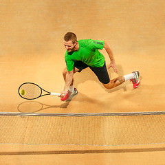 Image showing The one jumping player, caucasian fit man, playing tennis on the earthen court