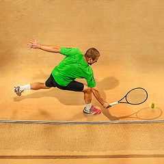 Image showing The one jumping player, caucasian fit man, playing tennis on the earthen court