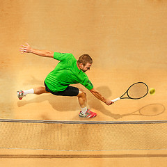 Image showing The one jumping player, caucasian fit man, playing tennis on the earthen court