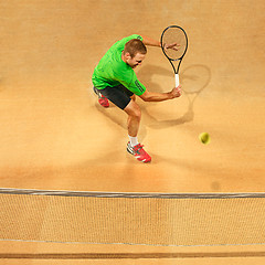 Image showing The one jumping player, caucasian fit man, playing tennis on the earthen court