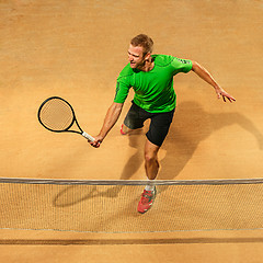 Image showing The one jumping player, caucasian fit man, playing tennis on the earthen court