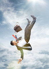 Image showing frightened businessman falling down and screaming