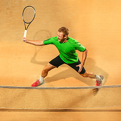 Image showing The one jumping player, caucasian fit man, playing tennis on the earthen court