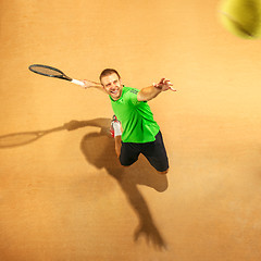 Image showing The one jumping player, caucasian fit man, playing tennis on the earthen court