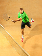 Image showing The one jumping player, caucasian fit man, playing tennis on the earthen court