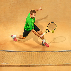 Image showing The one jumping player, caucasian fit man, playing tennis on the earthen court