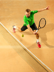 Image showing The one jumping player, caucasian fit man, playing tennis on the earthen court