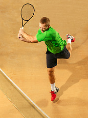 Image showing The one jumping player, caucasian fit man, playing tennis on the earthen court