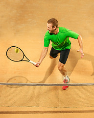 Image showing The one jumping player, caucasian fit man, playing tennis on the earthen court