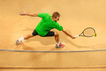 Image showing The one jumping player, caucasian fit man, playing tennis on the earthen court