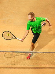 Image showing The one jumping player, caucasian fit man, playing tennis on the earthen court