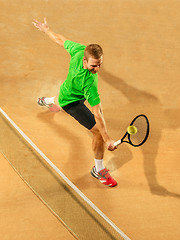 Image showing The one jumping player, caucasian fit man, playing tennis on the earthen court