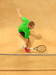 Image showing The one jumping player, caucasian fit man, playing tennis on the earthen court