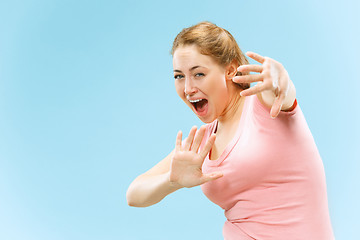 Image showing Portrait of the scared woman on blue