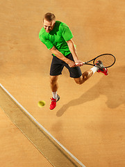 Image showing The one jumping player, caucasian fit man, playing tennis on the earthen court