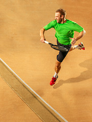 Image showing The one jumping player, caucasian fit man, playing tennis on the earthen court