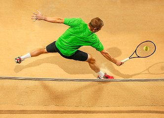 Image showing The one jumping player, caucasian fit man, playing tennis on the earthen court