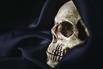 Image showing Closeup photo an old skull covered in black robe