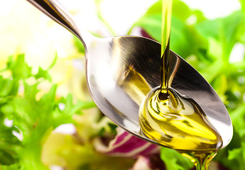 Image showing Olive oil being poured into a spoon and salad