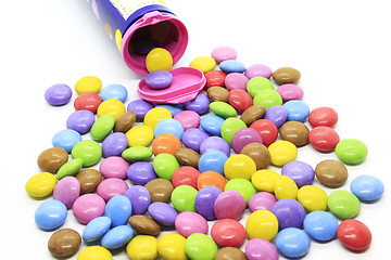 Image showing Multicolored glazed chocolate candies out of the container 