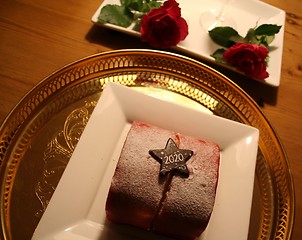 Image showing Pastry to celebrate the New Year 2020 with red Roses in background
