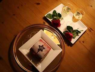 Image showing Pastry, red Roses and two glasses of champagne for the new Year 2020