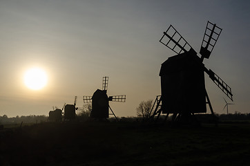 Image showing Traditional windmills silhouettes by the setting sun