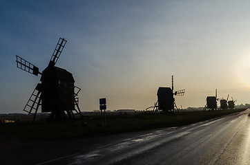 Image showing Old wooden windmill silhouettes in a row