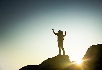 Image showing Man with arms raised at sunset