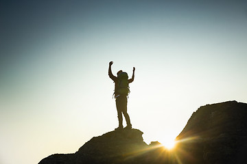 Image showing Man with arms raised at sunset