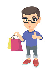 Image showing Happy caucasian boy holding shopping bags.