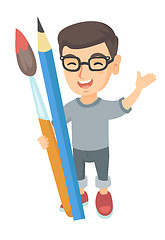 Image showing Smiling boy holding big pencil and paintbrush.