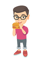 Image showing Little caucasian boy eating a hamburger.